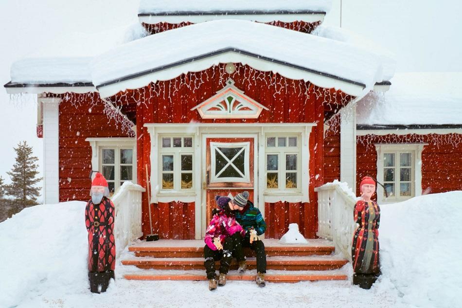 Aurelia Teslaru and Dan Moldovan sitting in front of Santa's home at Kakslauttanen Arctic Resort